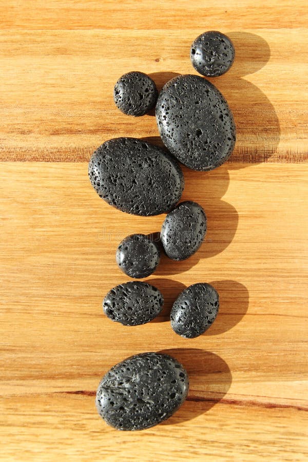 Superficie de madera con perlas de lava negras en un salón de spa - ideal para fondo o papel pintado imágenes de archivo libres de regalías Superficie de madera con perlas de lava negras en un salón de spa - ideal para fondo o papel pintado imágenes de archivo libres de regalías