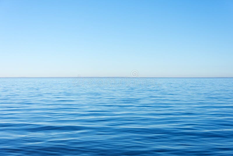 Superfície quieta da calma da água, o mar e o horizonte e céu claro