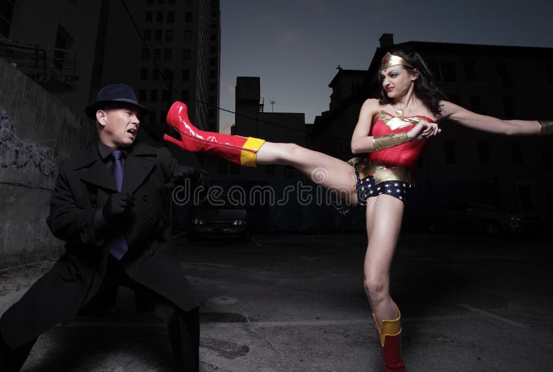 Superheld, der den schlechten Schuft tritt stockfotografie Superheld, der den schlechten Schuft tritt stockfotografie