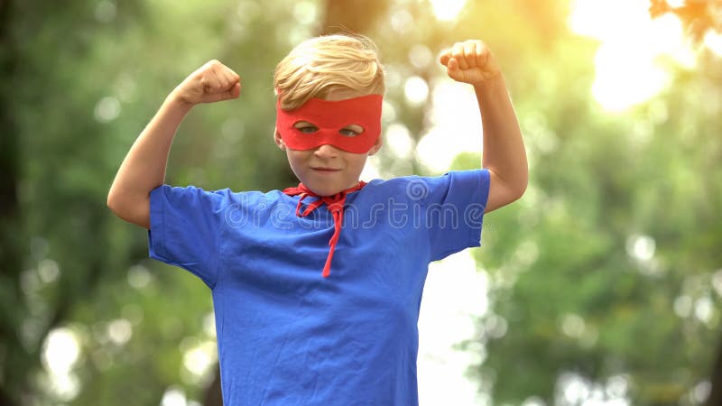 Superherojongen die spieren, spel als psychotherapie voor kindvertrouwen tonen