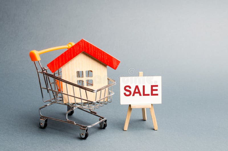 Supermarket cart with houses and a Sale Poster. The concept of selling a home, real estate services or buying from the owner. royalty free stock images Supermarket cart with houses and a Sale Poster. The concept of selling a home, real estate services or buying from the owner. royalty free stock images