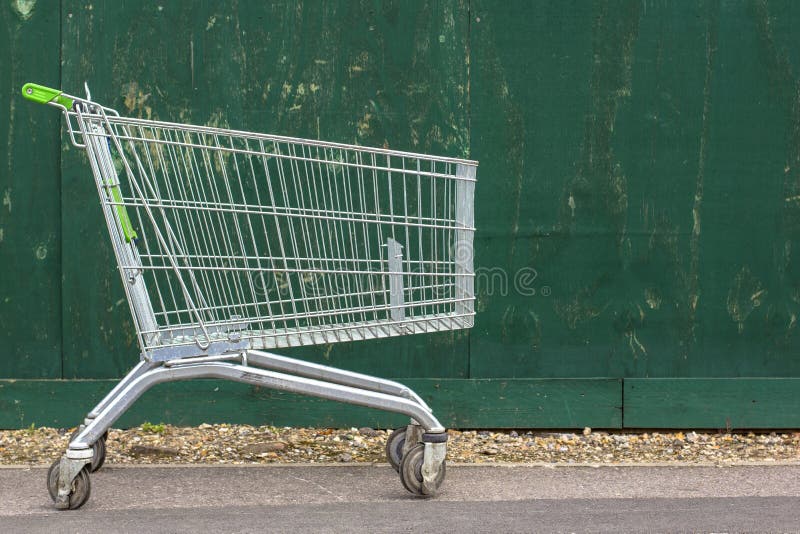 Supermarketa tramwaj na tle zielony ogrodzenie Supermarket fura na bruku zdjęcie royalty free Supermarketa tramwaj na tle zielony ogrodzenie Supermarket fura na bruku zdjęcie royalty free