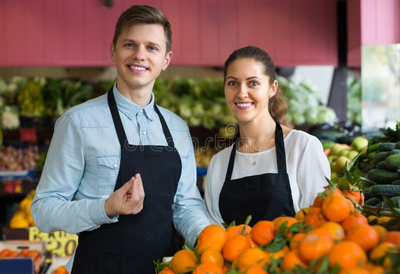 Supermarketarbetare som säljer apelsiner royaltyfri bild Supermarketarbetare som säljer apelsiner royaltyfri bild