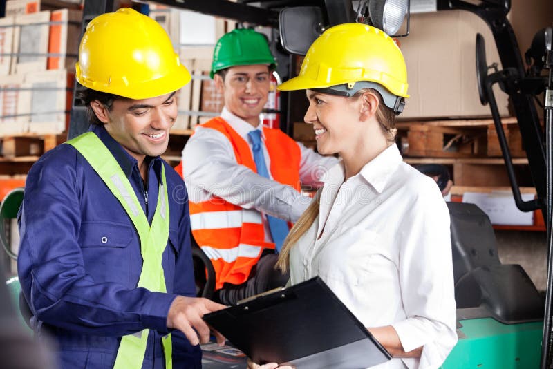 Supervisor Communicating With Foreman At Warehouse royalty free stock photo