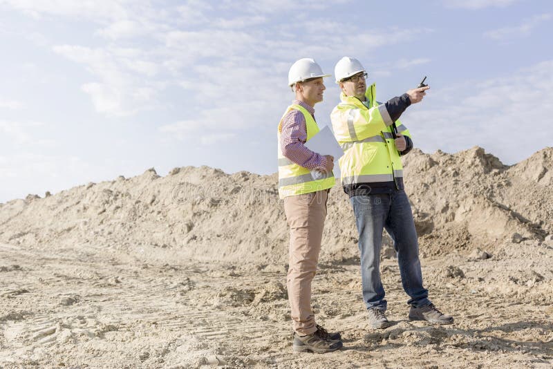 Supervisor examining construction site against sky