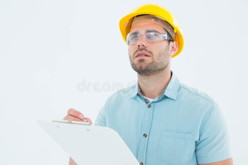Supervisor que olha ausente ao escrever na prancheta imagem de stock Supervisor que olha ausente ao escrever na prancheta imagem de stock