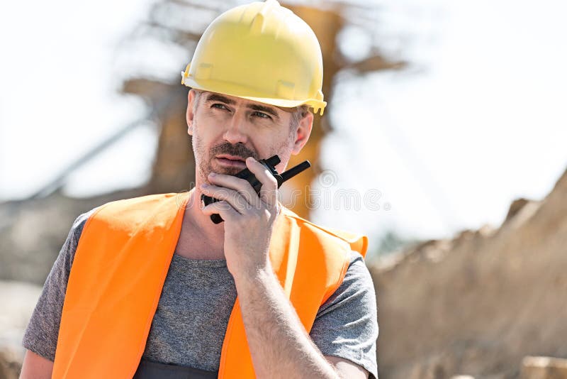 Supervisor seguro que usa o Walkietalkie no canteiro de obras fotos de stock royalty free Supervisor seguro que usa o Walkietalkie no canteiro de obras fotos de stock royalty free