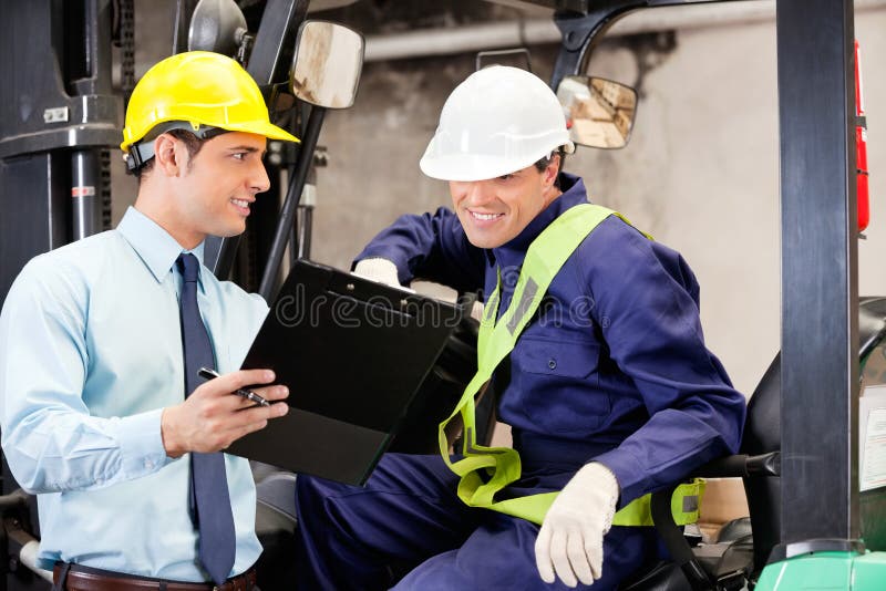 Supervisor Showing Clipboard To Forklift Driver royalty free stock image
