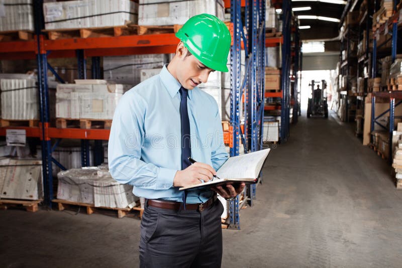 Supervisor Writing Notes At Warehouse stock images