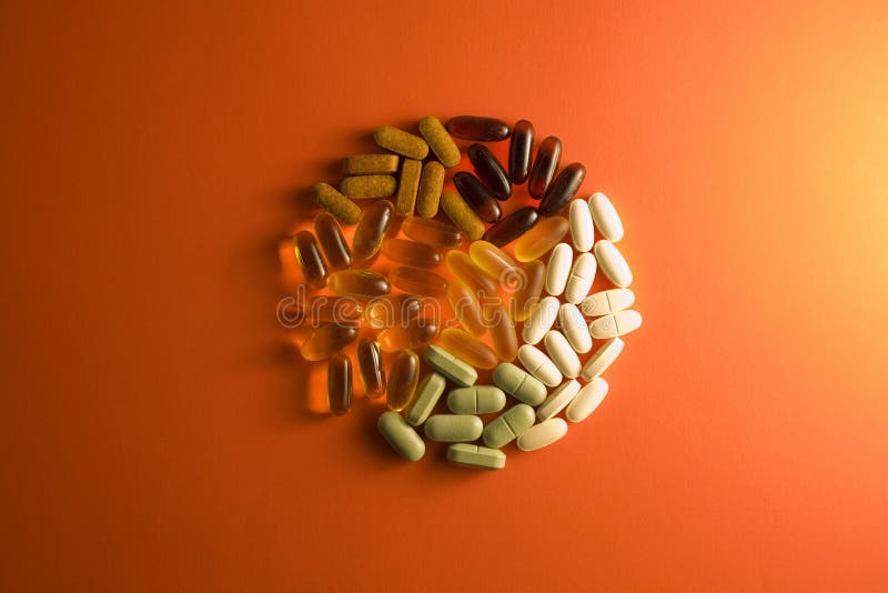 Multiple nutritional supplements on orange background. Multiple nutritional supplements on orange background