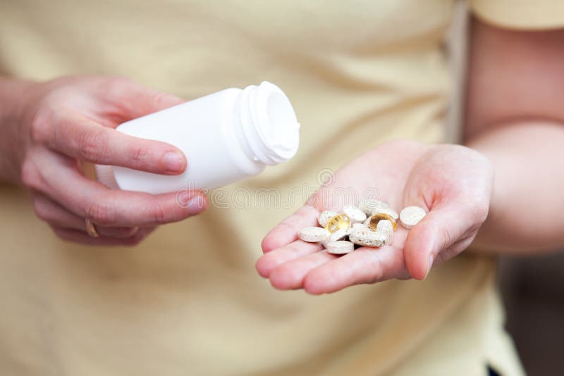 Nutritional supplements in the palm of your hand, a woman pours pills from a jar into the palm of her hand. Nutritional supplements in the palm of your hand, a woman pours pills from a jar into the palm of her hand