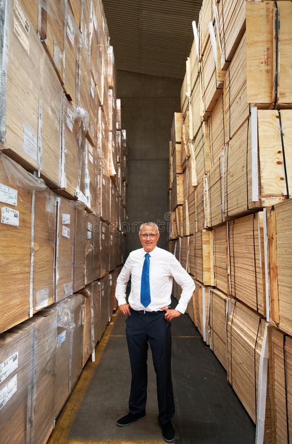 Supply chain, industry and management with leader looking proud in a warehouse, stock and product control. Mature manager checking supply, doing inventory in manufacturing factory with package orders.