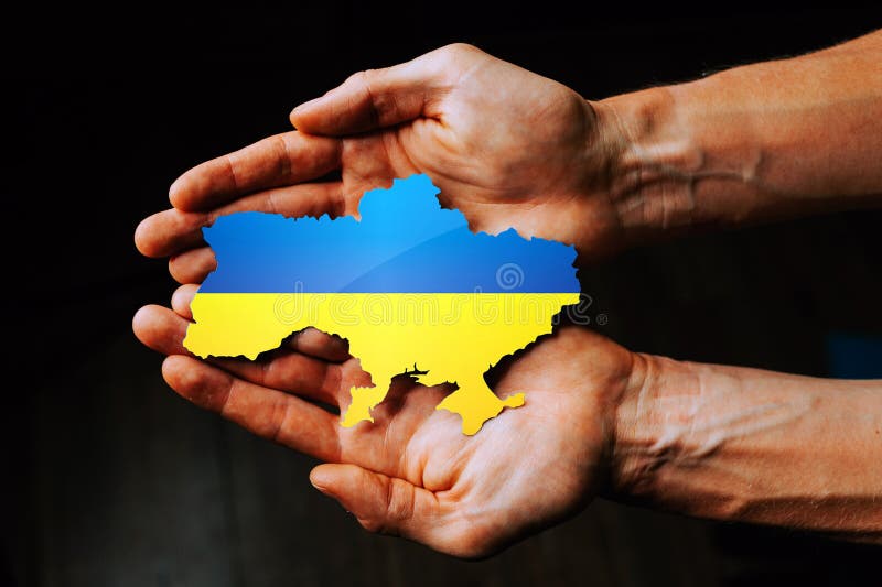 Support for Ukraine in the war with Russia. Hands holding the flag of Ukraine in the shape of the borders of Ukraine