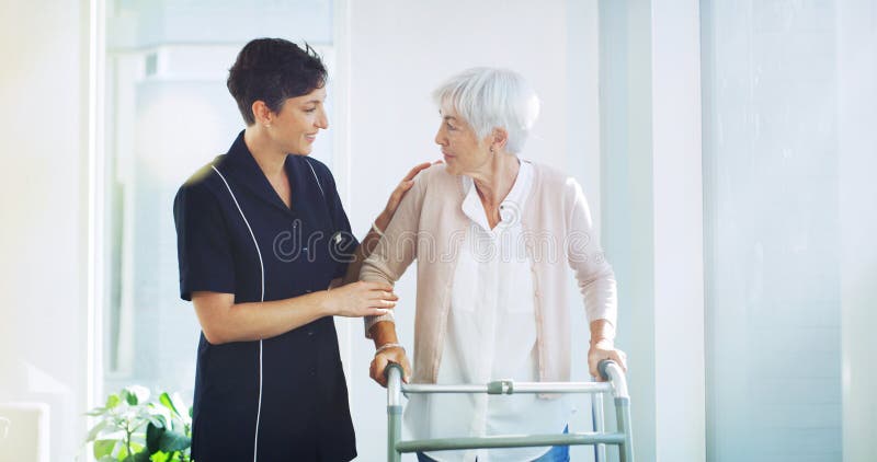 Supportare chi si prende cura di loro e la vecchia donna che cammina a casa per la fisioterapia sanitaria o per la pensione. Assis immagini stock libere da diritti