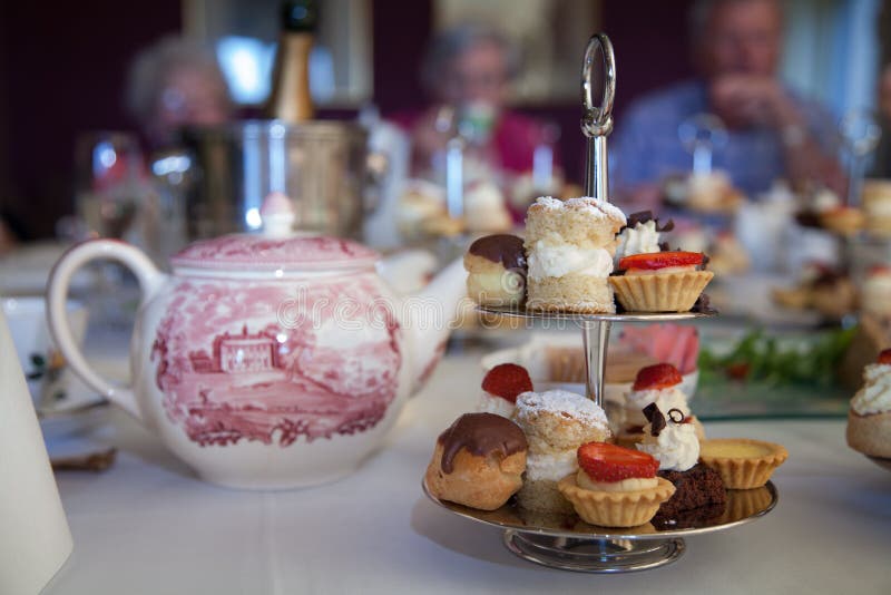 Cake stand with mini cakes on a table set for an afternoon tea party. Cake stand with mini cakes on a table set for an afternoon tea party