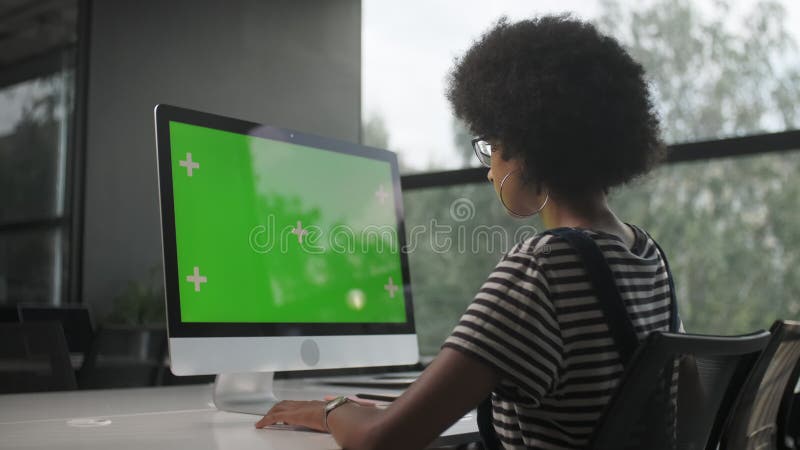 Sur le coup d'épaule d'une femme d'affaires travaillant dans l'intérieur de bureau sur le PC sur le bureau en regardant l'écran ve banque de vidéos