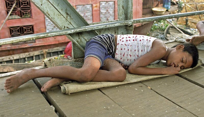 Sur le garçon sans abri de sommeil de rue, enfant de rue photographie stock libre de droits Sur le garçon sans abri de sommeil de rue, enfant de rue photographie stock libre de droits