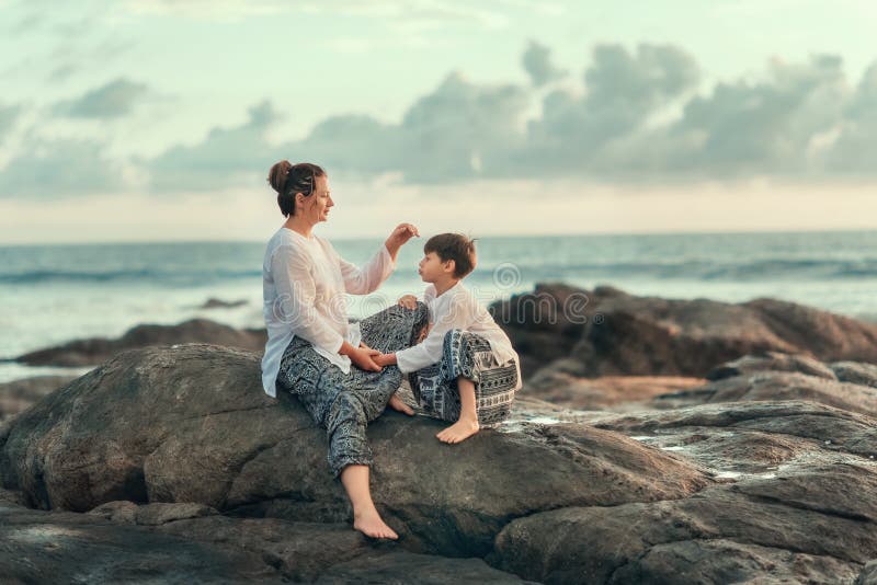 Sur les pierres de la mer, de la mère et du fils photo stock Sur les pierres de la mer, de la mère et du fils photo stock