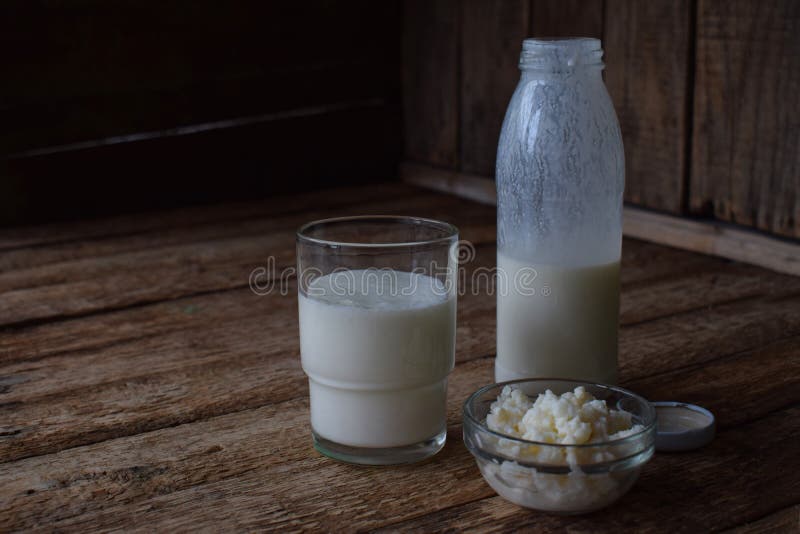 Sur-mejeri drink eller yoghurt i flaska som kommer från kefirkornen och mjölkar på träbakgrund Fotograferat med naturlig lig royaltyfri bild Sur-mejeri drink eller yoghurt i flaska som kommer från kefirkornen och mjölkar på träbakgrund Fotograferat med naturlig lig royaltyfri bild