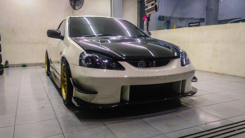 Surakarta Indonesia June 6 2018 white Honda Integra Type R DC5 in a car shop. Honda Integra type R DC 5 is the fourth generation of Honda Integra. Exclusively available in coupe configuration, this car also known as Acura RSX in USA. Powered by K20A engine that produced 222 horsepower. This car already modified by the owner using J'S racing bodykit from japan and using headlamps from facelift version. Surakarta Indonesia June 6 2018 white Honda Integra Type R DC5 in a car shop. Honda Integra type R DC 5 is the fourth generation of Honda Integra. Exclusively available in coupe configuration, this car also known as Acura RSX in USA. Powered by K20A engine that produced 222 horsepower. This car already modified by the owner using J'S racing bodykit from japan and using headlamps from facelift version.
