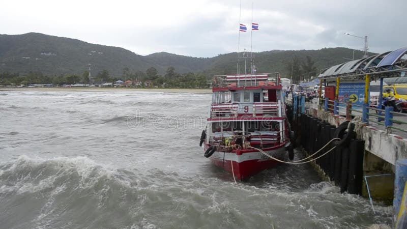 Suratthani Thailand - Augusti 02, 2019: Passagerarefartyg som ostadig flöte med starka vågor på Nathon färjaport