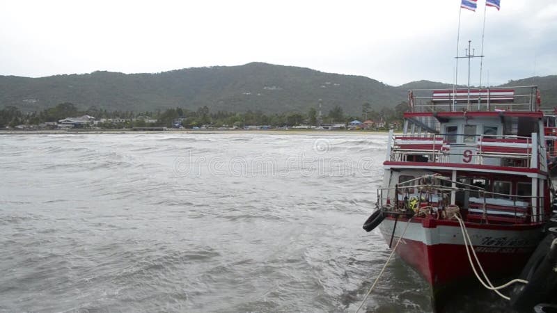 Suratthani Thailand - Augusti 02, 2019: Passagerarefartyg som ostadig flöte med starka vågor på Nathon färjaport