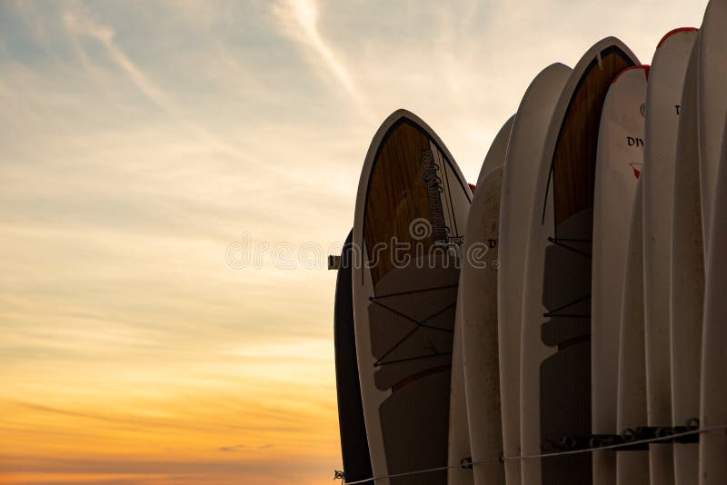 Surf boards standing up with a dramatic sunset behind on Waikiki royalty free stock image Surf boards standing up with a dramatic sunset behind on Waikiki royalty free stock image
