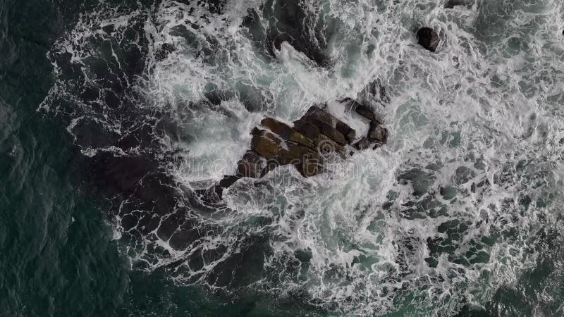 Surf lent entoure les rochers côtiers sur 2 banque de vidéos