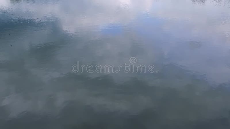 Surface lente de l'eau de MOIS du lac par temps calme un jour nuageux