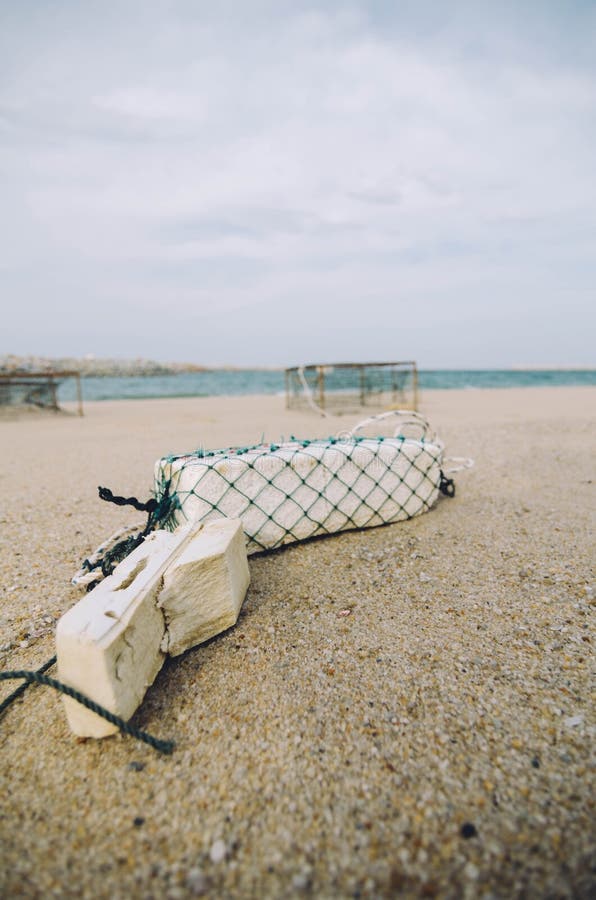 Surface level of white fish buoy on sandy beach over crab pot background royalty free stock photos Surface level of white fish buoy on sandy beach over crab pot background royalty free stock photos