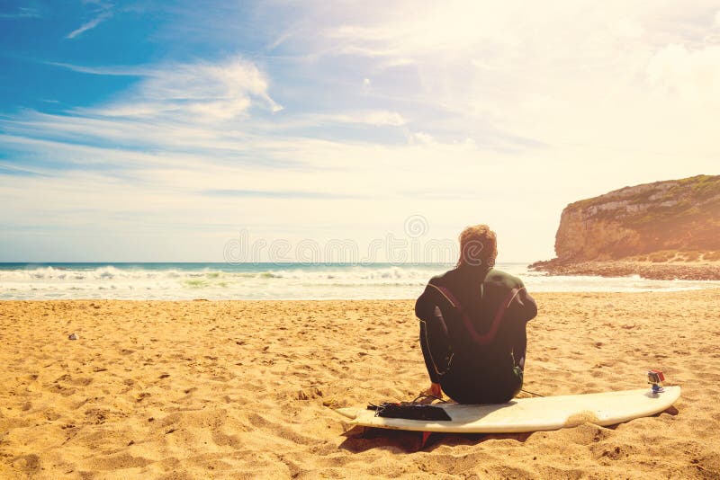 Surfer auf den Warteperfekten Wellen des Strandes lizenzfreies stockbild Surfer auf den Warteperfekten Wellen des Strandes lizenzfreies stockbild