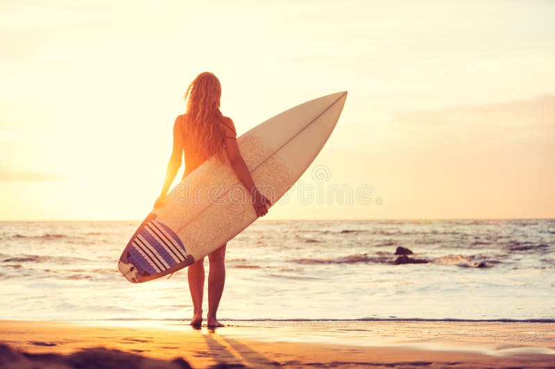 Bellissima sexy surfer girl sulla spiaggia al tramonto.