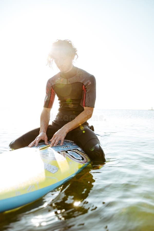 Surfer Man in Eyeglasses Sitting on Surf Board in Ocean Stock Image