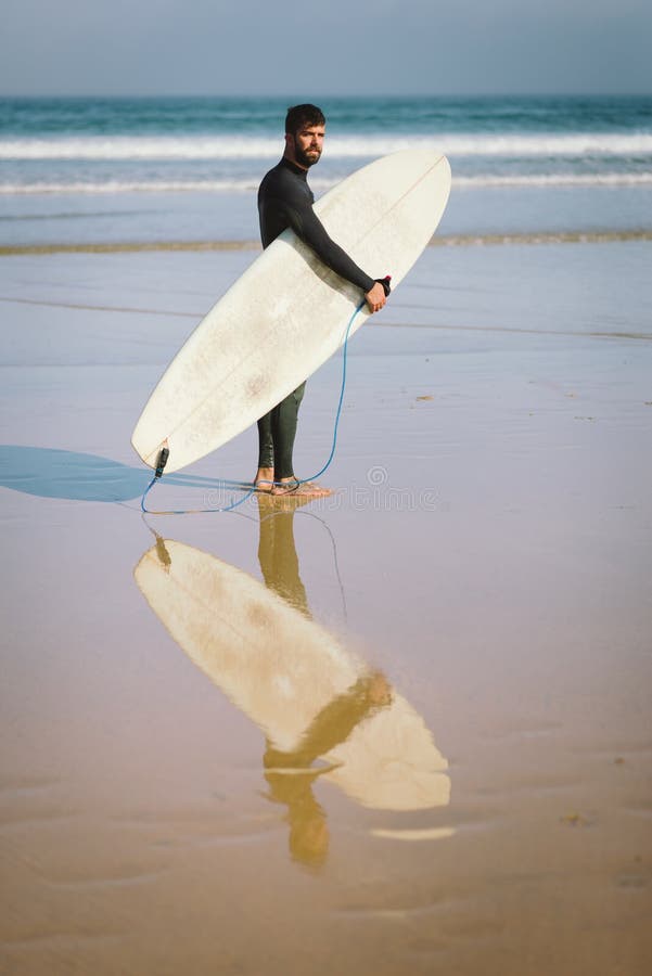 Surfer met zijn surfplank alvorens in het overzees voor surfin te krijgen royalty-vrije stock afbeelding Surfer met zijn surfplank alvorens in het overzees voor surfin te krijgen royalty-vrije stock afbeelding