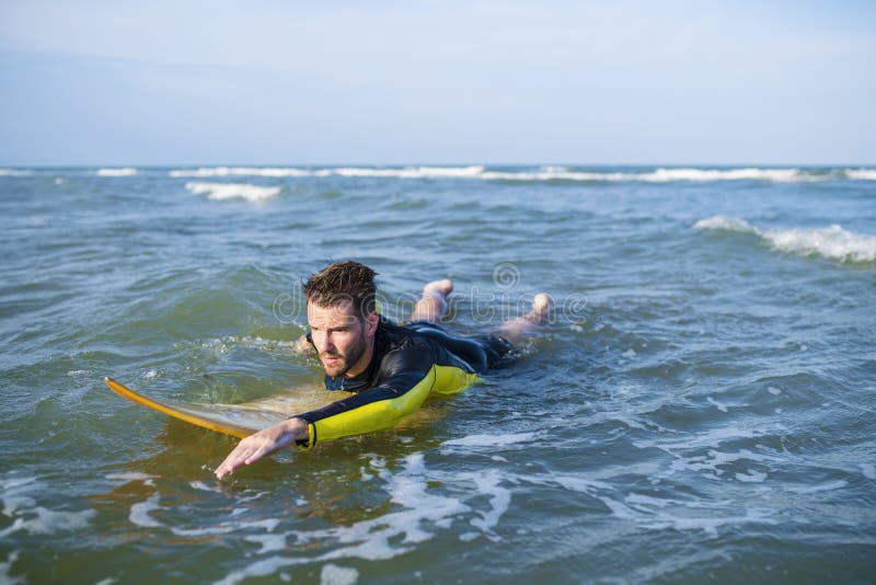 Surfer Guy Paddling With Surfboard At Sunset In Tenerife Stock Photo
