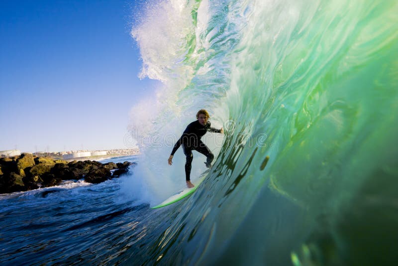 Surfer sur l'onde au coucher du soleil images stock