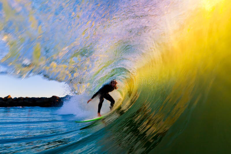 Surfer sur l'onde au coucher du soleil images libres de droits
