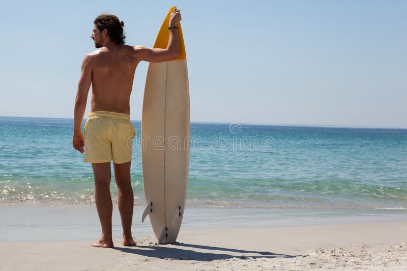 Male Surfer With Surfboard Looking At Sea On Beach Stock Photo Image