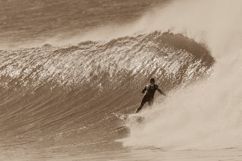 Surfing surfer rear behind photo bottom turning rides cold  offshore wind swept wave vintage sepia tone. Surfing surfer rear behind photo bottom turning rides cold  offshore wind swept wave vintage sepia tone.