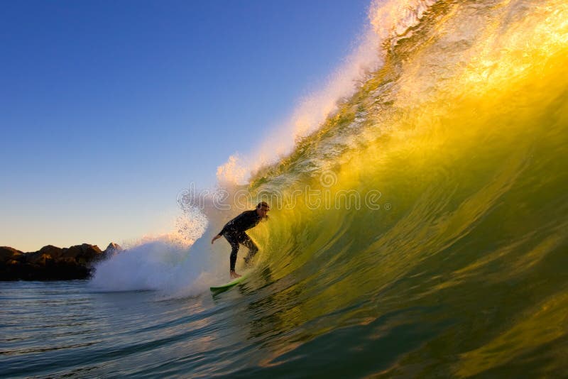 Surfer Ottiene un'Epica Barile Big Wave con Spiaggia a Sfondo al Tramonto.