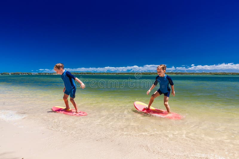 Surfer Twin Brothers Have Fun on Beach Learning To Surf Stock Photo