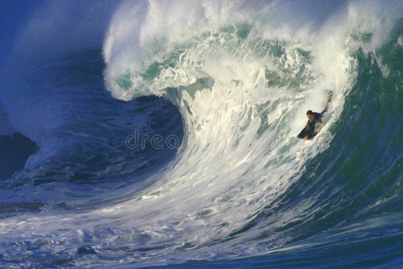 Surfer une grande onde au compartiment de Waimea en Hawaï images libres de droits Surfer une grande onde au compartiment de Waimea en Hawaï images libres de droits