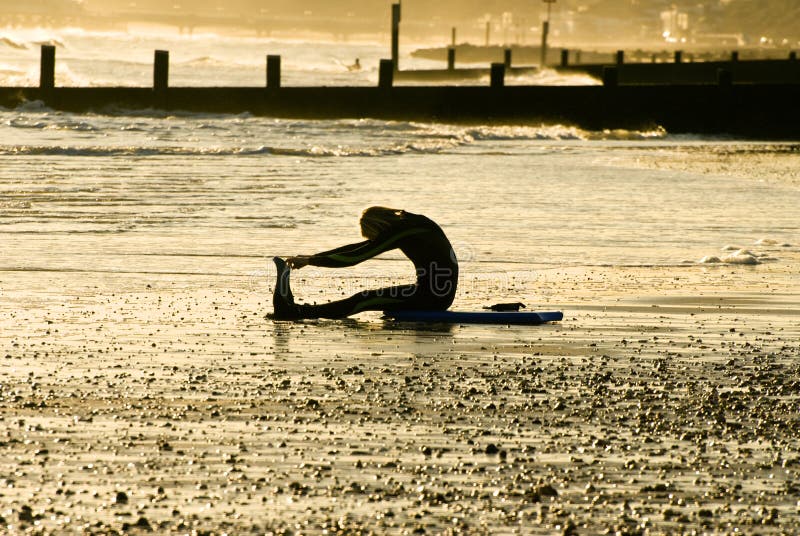 Surferr stretching on the beach