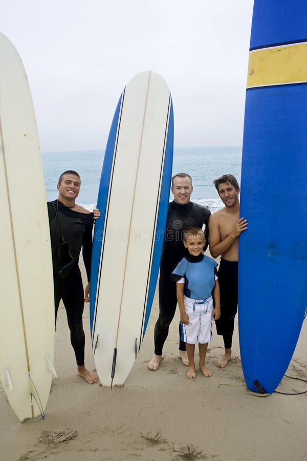 Eine Gruppe von Freunden, und ein junge, machen Sie sich bereit zu gehen, surfen, wie Sie posieren mit Ihren Surfbrettern.