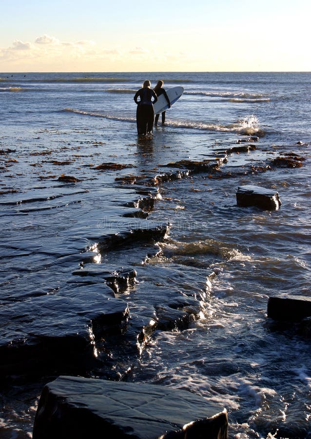 Surfers au compartiment de Kimmeridge, Dorset photos libres de droits Surfers au compartiment de Kimmeridge, Dorset photos libres de droits
