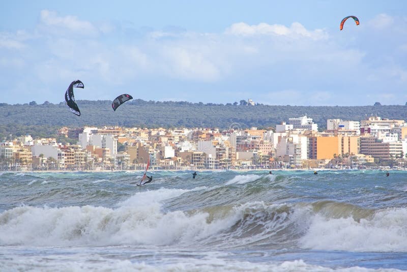 Surfers play in the green waves