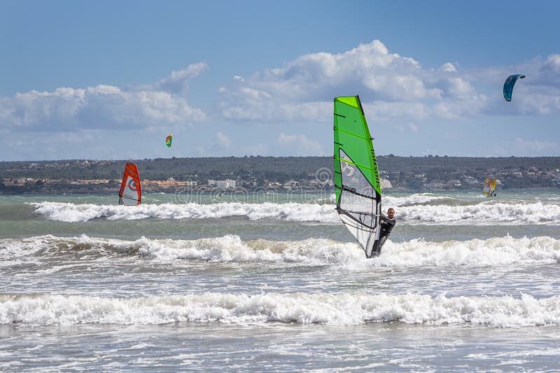 Surfers play in the green waves