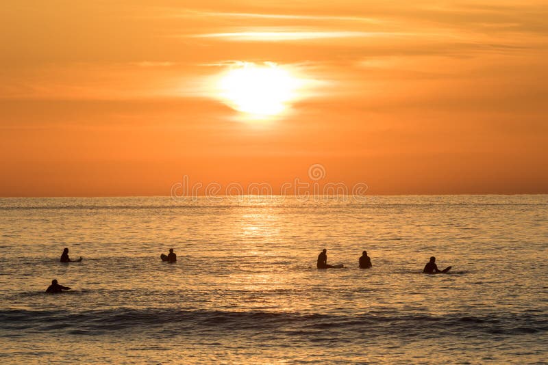 Surfers waiting in the water for the next wave. Sunset at Unstad beach royalty free stock photo Surfers waiting in the water for the next wave. Sunset at Unstad beach royalty free stock photo