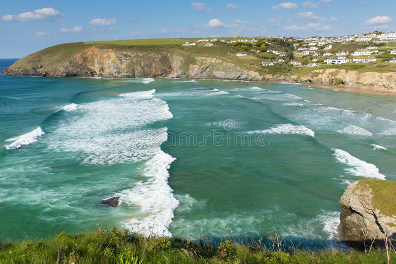 Surfing waves Mawgan Porth beach north Cornwall England near Newquay summer day with blue sky