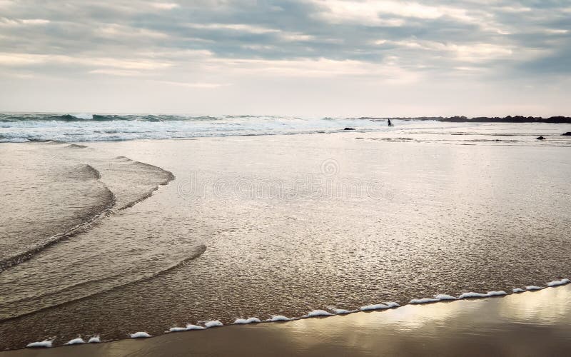 Surfingman mycket liten statyett på havstranden på soluppgångtid arkivfoton Surfingman mycket liten statyett på havstranden på soluppgångtid arkivfoton